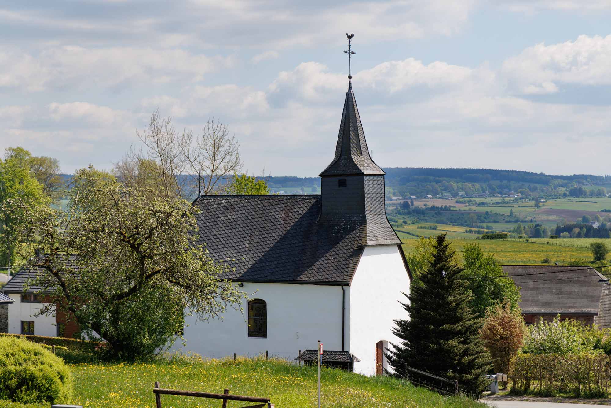 Chapelle d’Eibertingen entourée de prairies dans le paysage vallonné d’Amblève